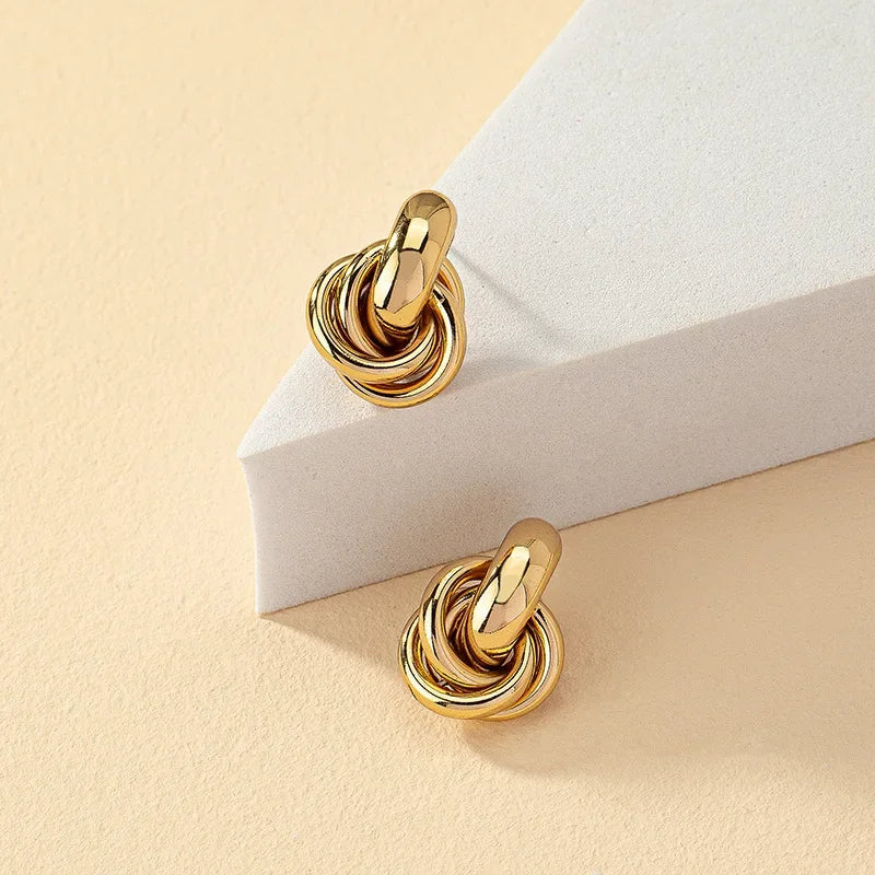 Pendientes de tuerca con forma de nudo para mujer, color oro y plata, chapado brillante, a la moda, bonitos, uso diario, joyería