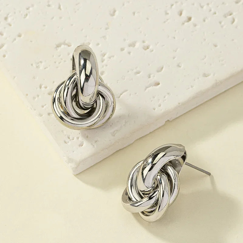 Pendientes de tuerca con forma de nudo para mujer, color oro y plata, chapado brillante, a la moda, bonitos, uso diario, joyería